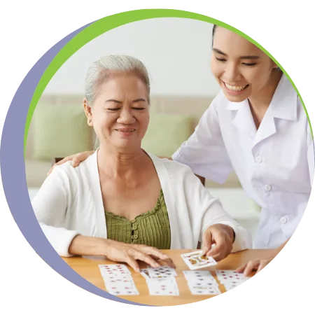 caregiver playing cards with elder woman