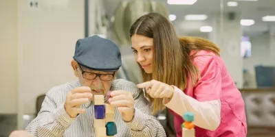 caregiver helping an alzheimers patient