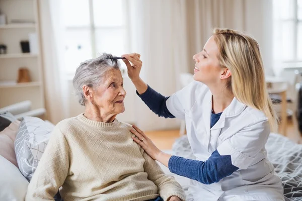 home aide brushing senior woman's hair