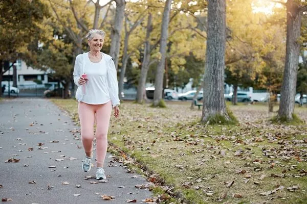 senior woman walking in park for cardo exercise